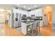 Bright kitchen boasts white cabinets, stainless appliances, eat-in island, and hardwood floors at 271 W 11Th St, Chuluota, FL 32766