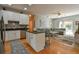 Open-concept kitchen featuring white cabinets, dark countertops, and stainless steel appliances with views to living room at 271 W 11Th St, Chuluota, FL 32766