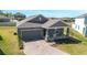 One-story home with a gray exterior, well-manicured lawn, and a brick driveway at 2837 Darlington Oak Ln, Ocoee, FL 34761