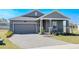 Charming one-story home with a gray exterior, brick driveway and manicured landscaping at 2837 Darlington Oak Ln, Ocoee, FL 34761