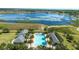 An aerial view of the community pool with well-maintained landscaping and a nearby lake at 2837 Darlington Oak Ln, Ocoee, FL 34761