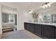 Well-lit bathroom with double sinks, dark cabinets, large mirror and a view of the main bedroom through the door at 2843 Maria Isabel Ave, Ocoee, FL 34761
