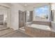 Bright bathroom with a soaking tub, a separate glass shower, and views of the outdoors through the window at 2843 Maria Isabel Ave, Ocoee, FL 34761
