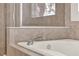 Close-up of a bathtub with a chrome faucet and shower with glass doors at 2843 Maria Isabel Ave, Ocoee, FL 34761