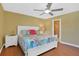 Comfortable bedroom features a ceiling fan, ensuite bathroom, and bright floral bedding at 33 Sea Haven Dr, Ponce Inlet, FL 32127