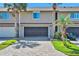 Inviting townhouse with a gray brick driveway and a one-car garage with tropical landscaping at 33 Sea Haven Dr, Ponce Inlet, FL 32127