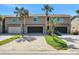 Townhouse exterior showcasing a well-manicured lawn, gray brick driveways, and tropical landscaping at 33 Sea Haven Dr, Ponce Inlet, FL 32127