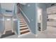 Hallway featuring stairs with wooden steps, tile floors, and a view into the kitchen area at 33 Sea Haven Dr, Ponce Inlet, FL 32127