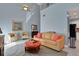 Bright living room with high ceilings, tile floors, sofa, and tropical-themed accent chairs at 33 Sea Haven Dr, Ponce Inlet, FL 32127