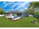 Beautiful backyard featuring a screened-in pool, patio, and lush green lawn at 33215 Kaylee Way, Leesburg, FL 34788