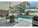 Inviting screened-in patio area with ample seating, lush landscaping, and a ceiling fan at 33215 Kaylee Way, Leesburg, FL 34788