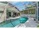 Inviting screened-in pool area with ample seating, lush landscaping, and a ceiling fan at 33215 Kaylee Way, Leesburg, FL 34788