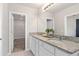 Modern bathroom featuring double sinks with granite countertops and access to closet at 3611 Cambridge Brook Dr, Davenport, FL 33837