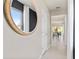 Bright hallway with neutral walls, tile flooring, and a decorative mirror; glimpses of the dining room beyond at 3611 Cambridge Brook Dr, Davenport, FL 33837