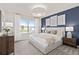 Comfortable bedroom with a king-size bed, dark blue accent wall and bright natural light at 3611 Cambridge Brook Dr, Davenport, FL 33837