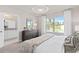 Bright bedroom with a view to the outside, featuring a wooden dresser and an ensuite bathroom at 3611 Cambridge Brook Dr, Davenport, FL 33837