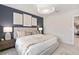 Cozy bedroom featuring a king-size bed, stylish lamps, and a dark blue accent wall at 3611 Cambridge Brook Dr, Davenport, FL 33837