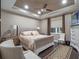 Spacious bedroom with tray ceiling, ceiling fan, and a cozy king-size bed with decorative pillows at 3637 Chandler Estates Dr, Apopka, FL 32712