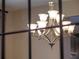 Close-up of a modern chandelier with frosted shades, showcasing its design and ambient lighting at 3637 Chandler Estates Dr, Apopka, FL 32712