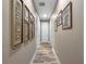 Bright hallway with wood-look flooring and framed art leading to various rooms in the home at 3637 Chandler Estates Dr, Apopka, FL 32712