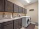 Well-equipped laundry room with dark cabinetry, a sink, and modern washer and dryer appliances at 3637 Chandler Estates Dr, Apopka, FL 32712