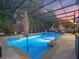Inviting screened-in pool with waterfall feature, lush landscaping, and comfortable seating for relaxation and entertainment at 3637 Chandler Estates Dr, Apopka, FL 32712