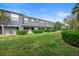 Exterior townhouse view showcasing well-maintained lawn, mature landscaping, and patio at 3664 Wilshire Way Rd # 261, Orlando, FL 32829