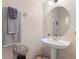 This half-bath features a pedestal sink, oval mirror, soft lighting, and decorative towels at 3664 Wilshire Way Rd # 261, Orlando, FL 32829