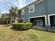 Back exterior view of townhome with a patio, green lawn, and palm trees in landscaping at 3664 Wilshire Way Rd # 261, Orlando, FL 32829