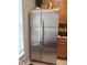 A stainless steel refrigerator, complete with double doors, is situated next to wooden cabinets and a tiled floor at 3664 Wilshire Way Rd # 261, Orlando, FL 32829