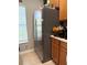 A stainless steel refrigerator, complete with double doors, is situated next to wooden cabinets and a tiled floor at 3664 Wilshire Way Rd # 261, Orlando, FL 32829