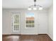 Well-lit dining area with wood floors features a modern light fixture, a window and access to the outside at 4355 Perkinshire Ln # 103, Orlando, FL 32822