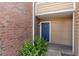 Image showing a brick apartment with a blue front door and green bushes lining the walkway at 4355 Perkinshire Ln # 103, Orlando, FL 32822