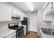 Bright kitchen features white cabinets, a stainless steel refrigerator and a black electric range at 4355 Perkinshire Ln # 103, Orlando, FL 32822