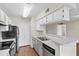 Modern kitchen with white cabinets, stainless steel appliances and open breakfast bar into living space at 4355 Perkinshire Ln # 103, Orlando, FL 32822