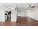 Open-concept living room features wood floors, neutral paint, a ceiling fan and a breakfast bar overlooking the kitchen at 4355 Perkinshire Ln # 103, Orlando, FL 32822