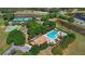 This aerial shot of the neighborhood pool and tennis courts shows surrounding trees and convenient access at 4718 Magnetite Loop, Mount Dora, FL 32757