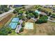 Aerial view shows a community pool and tennis courts surrounded by lush landscaping at 4718 Magnetite Loop, Mount Dora, FL 32757