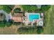 Aerial view showcasing a pool area with palm trees, plenty of lounging space, and a nearby clubhouse at 4718 Magnetite Loop, Mount Dora, FL 32757