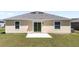 This single-Gathering home features a sliding glass door that leads to a concrete patio with a well-maintained lawn at 4718 Magnetite Loop, Mount Dora, FL 32757