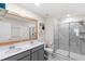 Bathroom featuring double sinks, gray cabinets, framed mirror, and a glass-enclosed shower at 4718 Magnetite Loop, Mount Dora, FL 32757
