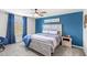 Cozy bedroom features a blue accent wall, wood-frame bed, and soft, neutral carpeting at 4718 Magnetite Loop, Mount Dora, FL 32757