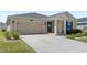 Inviting home exterior featuring a two-car garage, neat landscaping, and a covered entryway at 4718 Magnetite Loop, Mount Dora, FL 32757