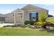 Attractive one-story home with a manicured lawn and beautiful landscaping at 4718 Magnetite Loop, Mount Dora, FL 32757