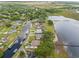 Aerial shot of waterfront properties with docks extending into a lake surrounded by lush greenery and neighborhood views at 720 Basin Dr, Kissimmee, FL 34744