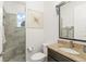 Stylish bathroom showcasing a tiled shower and granite countertop with a dark wood vanity at 720 Basin Dr, Kissimmee, FL 34744