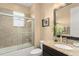 Well-lit bathroom with tiled shower, granite countertop, and dark wood vanity at 720 Basin Dr, Kissimmee, FL 34744