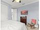 Neutral bedroom with grey walls featuring ceiling fan, rocking chair and dresser at 720 Basin Dr, Kissimmee, FL 34744