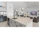 Modern kitchen featuring a large granite island, stainless steel appliances, and gray cabinets at 720 Basin Dr, Kissimmee, FL 34744