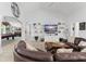 Cozy living room featuring a comfortable leather couch, vaulted ceilings, and an adjacent recreation room at 720 Basin Dr, Kissimmee, FL 34744